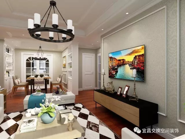  客廳硬裝沒有過于復雜，電視背景僅僅以線條框出一個造型，但暗紋的設計，展現了美式的精致。簡單的電視柜搭配矮矮的茶幾，突出簡約的態度。